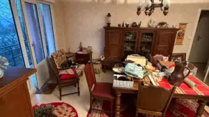 Salle à manger avec meubles anciens et table encombrée