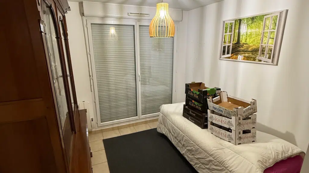 chambre avec des cartons posés sur le lit